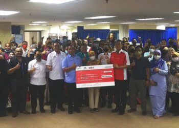 Kamaruzaman  Johari (depan tujuh dari kiri) bersama para penerima pinjaman agensi KUSKOP di Shah Alam, semalam. -UTUSAN/ABDUL RAZAK IDRIS