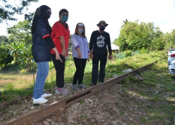 MARY Josephine Prittam Singh (dua dari kiri) dan Shamaruddin (kanan) menunjukkan landasan keretapi lama berusia 130 tahun di Kampung Chedang, Seremban yang akan dijadikan satu produk pelancongan. - UTUSAN/ZAKKINA WATI AHMAD TARMIZI.