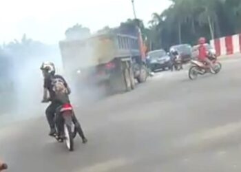TANGKAP layar kejadian tiga penunggang motosikal dan sebuah lori melanggar lampu isyarat merah sehingga hampir berlaku kemalangan di Kampung Acheh, Sitiawan kelmarin. -  UTUSAN/MEDIA SOSIAL