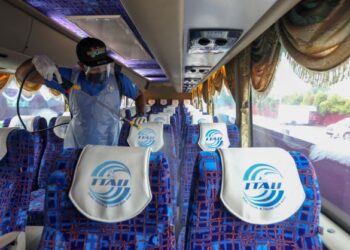PETUGAS melakukan sanitasi dalam bas persiaran, semalam sebagai persediaan pembukaan semula Langkawi di bawah program gelembung pelancongan, hari ini. –  UTUSAN/ SHAHIR NOORDIN