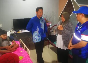 MARINA Mukhtar (dua dari kanan) menerangkan keadaan Rafhique kepada Hizatul Isham sambil di Padang Jawa, Selangor.- UTUSAN/ABDUL RAZAK IDRIS