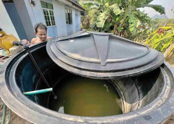 SEORANG penduduk, menunjukkan keadaan air di rumahnya yang agak keruh sehinggakan terpaksa menggunakan penapis di Kampung Kubang Tiga, Padang Besar, Perlis, baru-baru ini. – UTUSAN/ASYRAF MUHAMMAD