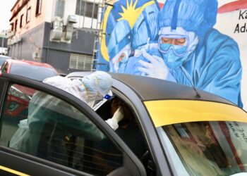 Petugas kesihatan melakukan ujian saringan Covid-19 orang awam secara pandu lalu di Seksyen 7, Shah Alam, Selangor, semalam berikutan peningkatan mendadak kes harian. – UTUSAN/ZULFADHLI ZAKI