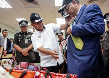 SAIFUDDIN Nasution Ismail mengenakan tali leher batik yang dihasilkan oleh banduan pada timbalannya, Datuk Seri Dr. Shamsul Anuar Nasarah (kanan) ketika meninjau Galeri Vokasional dan Industri sempena lawatan rasmi beliau ke Ibu Pejabat Jabatan Penjara di Kajang, hari ini. - UTUSAN/MUHAMAD IQBAL ROSLI