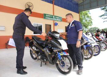 AB. Aziz Awang Teh (kanan) menunjukkan motosikal yang disita dalam Op Lejang dalam sidang akhbar di Pejabat JPJ Perak di Ipoh, Perak, hari ini. - UTUSAN/MUHAMAD NAZREEN SYAH MUSTHAFA