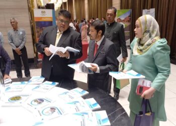 KETUA Perangkawan, Datuk Seri Dr. Mohd. Uzir Mahidin menunjukkan kepada Ab. Rauf Yusoh buku data perangkaan Dewan Undangan Negeri (DUN) Melaka selepas perasmian Jelajah Penemuan Utama Banci Malaysia 2020 dan Sosio Ekonomi 2021 di Ayer Keroh, Melaka. - UTUSAN/AMRAN MULUP
