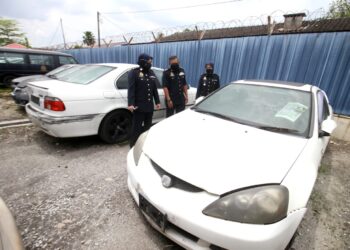 PEGAWAI JPJ menunjukan antara kereta yang di lelong JPJ Perak, Ipoh, Perak, hari ini. - UTUSAN/ZULFACHRI ZULKIFLI