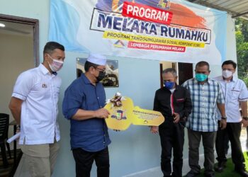 SULAIMAN Md. Ali (dua dari kiri) menyerahkan replika kunci kepada penerima Abdul Wahab Mohamad pada Program Melaka Rumahku di Durian Tunggal, Melaka. - UTUSAN/DIYANATUL ATIQAH ZAKARYA
