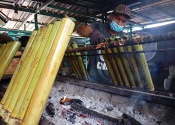 AMRAN Kasim menyusun lemang yang siap dibakar untuk dijual kepada pelanggan terutama pelancong luar di gerainya di Simpang Ampat, Alor Gajah, Melaka. - UTUSAN/MUHAMMAD SHAHIZAM TAZALI