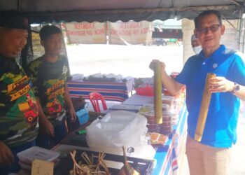 Muhammad Hydier Hamid (kiri) melayan pelanggannya di Kampung Salak Tinggi, Selangor hari ini. - UTUSAN/ABDUL RAZAK IDRIS