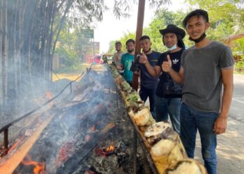 SYAFIK (dua kanan) bersama pekerja di gerai Lemang Kasih Sayang di Kampung Sungai Kelong, Pasir Puteh, Kelantan, hari ini. - UTUSAN/TOREK SULONG