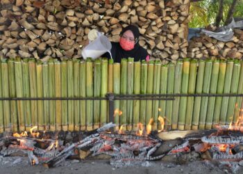 AZLYNA Shazlin Johari memasukkan santan ke dalam buluh  lemang di gerai Lemang Manong di Taman Meru 2C, Ipoh hari ini. - UTUSAN/ZULFACHRI ZULKIFLI.