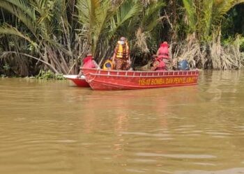 ANGGOTA bomba mencari mangsa lemas di Sungai Perak dekat Kampung Tebing Rebak di Hutan Melintang, semalam. - IHSAN JBPM