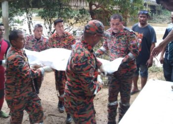 ANGGOTA bomba mengusung mayat Muhammad Haikal Muktar yang ditemukan lemas di bawah jambatan Sungai Berang dekat Kampung Pengkalan Ajal, Ajil, Hulu Terengganu, hari ini. - UTUSAN/NOOR HAYATI MAMAT