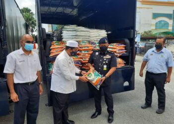 KAMARUL ZAMAN MAMAT (dua dari kanan) menerima sumbangan beras daripada Ahmad Tarmizi Sulaiman di Alor Setar hari ini. -  UTUSAN/MOHD. RIFAAT ABD. HAMID