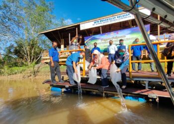 KASIM Tawe (depan, dua dari kiri) melepaskan benih ikan sempena Majlis Pelepasan Benih Ikan Serentak Seluruh Negara dan Demonstrasi Produk Perikanan di Pengkalan Nelayan Sungai Timun, Rembau, hari ini.-UTUSAN/NOR AINNA HAMZAH