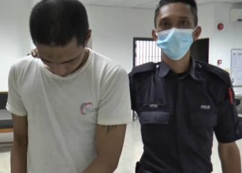 TERTUDUH dibawa oleh polis pengiring semasa menghadiri perbicaraan di Mahkamah Sesyen, Kota Bharu, hari ini.