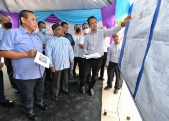 AMINUDDIN Harun dan Mohd. Khairuddin mendengar taklimat selepas perasmian Majlis Pecah Tanah Pembinaan Loji Rawatan Air Ngoi-Ngoi Fasa 2 di Pantai, Seremban, Negeri Sembilan,  semalam. - UTUSAN/MOHD. SHAHJEHAN MAAMIN