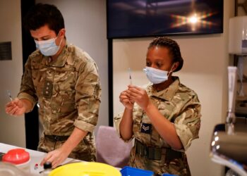 ANGGOTA tentera membantu memberikan suntikan vaksin di Stadium Wembley, London.-AFP