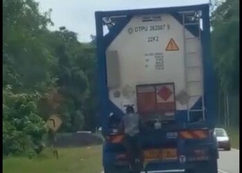 TULAR seorang lelaki yang melakukan aksi lagak ngeri dengan berpaut pada belakang treler di Lanchang, Temerloh, kelmarin.