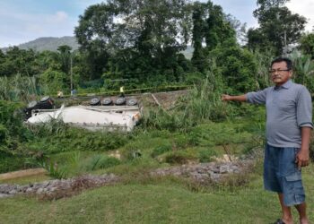 NIZAR Ahmad menunjukkan keadaan sebuah lori tangki membawa muatan 50 tan metrik simen yang terbabas di selekoh Kampung Chenaga, Jalan Repah-Kuala Pilah, Tampin, Negeri Sembilan, awal pagi ini. - UTUSAN/NOR AINNA HAMZAH.