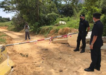SIK Choon Foo (kiri) meninjau lorong tikus yang ditutup dengan penghadang besi di Kampung Tanah Putih, Gua Musang, Kelantan. - UTUSAN/AIMUNI TUAN LAH