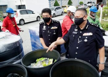 MAZLAN Santarai (kanan) menunjukkan dadah bernilai lebih RM58 juta untuk dilupuskan pada Majlis Perlupusan Barang Kes Narkotik di IPK Perak di Ipoh, Perak, hari ini. - UTUSAN/ZULFACHRI ZULKIFLI