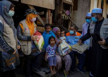 Zulkifli Wahijan (tiga dari kanan) menyerahkan bantuan keperluan asas kepada seorang penerima dalam Misi Bantuan Kemanusiaan Sabah oleh Muslim Care Malaysia (MCM) bagi meringankan beban penduduk yang terjejas akibat Covid-19 di Pulau Mabul, Sabah, baru-baru ini.  UTUSAN/FARIZ RUSADIO