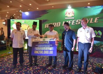 RONALD Kiandee (tengah) menyerahkan Geran Kajian Inovasi Mekanisasi dan Automasi Pertanian sambil 
disaksikan Ahmad Tarmizi Sulaiman (dua dari kanan) dan Kamarudin Dahuli (kanan) pada pelancaran 
MASPRO di Taman Ekspo Pertanian Malaysia Serdang, kelmarin. – UTUSAN/MUHAMAD IQBAL ROSLI