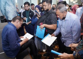 ANWAR Ibrahim menandatangani buku Membangun Negara Madani: Visi dan Kerangka Dasar Reformasi selepas melancarkannya di ibu negara, hujung tahun lalu. – UTUSAN/FAUZI BAHARUDIN