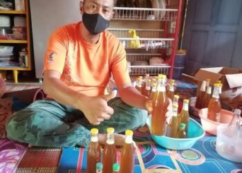 MASRI Muhamad menunjukkan madu lebah Tualang yang siap diisi ke dalam botol untuk dijual di Kampung Kuala Sat, Hulu Tembeling di Jerantut, Pahang. – UTUSAN/HARIS FADILAH AHMAD