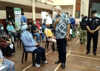 MAHDZIR KHALID beramah mesra dengan sebahagian penerima suntikan vaksin di Dewan Tunku Putera di Kuala Nerang, Padang Terap, hari ini.