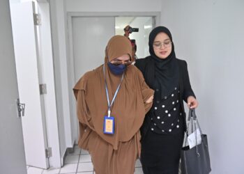 EZZA Suria Muda (kiri) yang mengaku bersalah memalsuan dokumen Penjana Kerjaya dibawa keluar dari Mahkamah Sesyen, Kuala Terengganu, hari ini. - UTUSAN/PUQTRA HAIRRY ROSLI