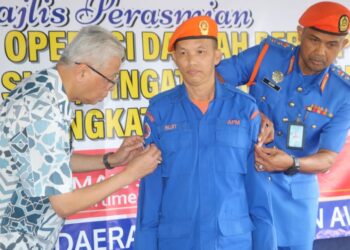 ISMAIL SABRI Yaakob (kiri) memakaikan pangkat kepada anggota APM pada majlis penyerahan sijil, pingat pertahanan awam di Pusat Kawalan Operasi Bencana APM Bera di Bera, Pahang. - UTUSAN/ SALEHUDIN MAT RASAD