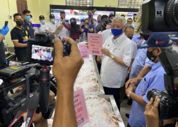 ISMAIL SABRI Yaakob menunjukkan ayam segar yang dijual dengan harga RM5 pada Majlis Pelancaran Pasaraya MG Coopmart dan Jualan Harga Murah Semarak Ramadan Keluarga Malaysia serta Penyampaian Bantuan Banjir Keluarga Malaysia di Pasaraya MG Coopmart Cawangan Bera di Bera, Pahang. - UTUSAN/NORHAFIZAN ZULKIFLI