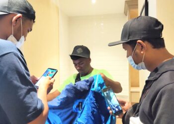 AZIM Afifi (tengah) menyerahkan pakaian dan kelengkapan kepada ahli keluarga Muhammad Hawari.