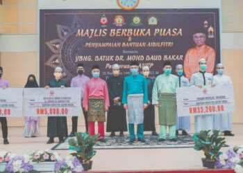 MOHD. Daud Bakar (tengah) dan pegawai Majlis Agama Islam Wilayah Persekutuan bersama penerima bantuan Aidilftri baru-baru ini.