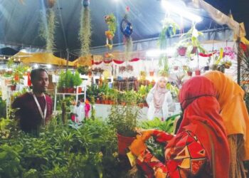 IRWAN PUTEH (kiri) melayan pengunjung yang memilih pokok yang dijual di gerai Mekar Klasik Farm & Nursery sempena FMJ 2022.