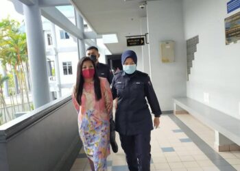 ZALIFAH Salleh (kiri) diiring anggota polis selepas dihukum penjara sehari dan denda RM1,200 akibat kesalahan mencuri yang dilakukannya di Mahkamah Majistret di Ayer Keroh, Melaka. UTUSAN/ DIYANATUL ATIQAH ZAKARYA