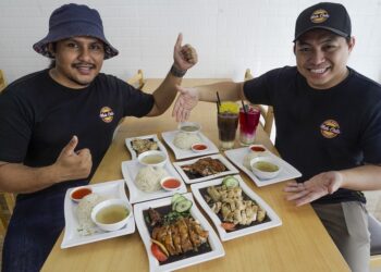 HMAD Fadhilat Fitri (kanan) dan Eksekutif Pemasaran Nasi Ayam Mak Chili, Isaac Osman menunjukkan menu yang terdapat di restoran berkenaan.