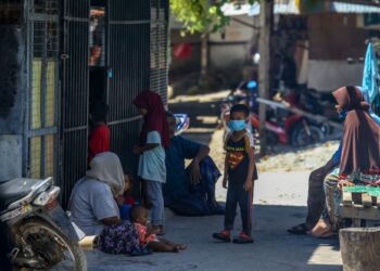 PENDUDUK Bukit Malut berbual-bual di hadapan rumah mereka.