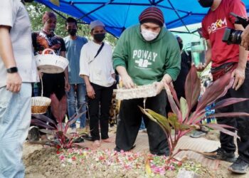 ANAK Allahyarham Mamat Khalid, Mohd. Khalid Amen menabur bunga  di kubur bapanya yang selamat dikebumikan di Tanah Perkuburan Islam Masjid Kampong Paloh, Ipoh sebentar tadi. - FOTO/ZULFACHRI ZULKIFLI