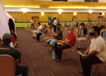 SEBAHAGIAN daripada pekerja industri maritim menunggu giliran untuk divaksin di Hotel Ritz Garden, Seri Manjung di Lumut, Perak, hari ini. - UTUSAN/SHAMSUL KAMAL AMARUDIN