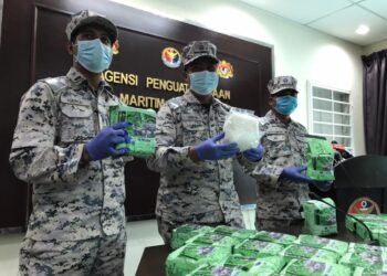 NURUL Hizam Zakaria (tengah) menunjukkan 38 bungkusan dadah dipercayai jenis syabu yang ditemukan dalam bagasi di perairan Muar, Johor. -UTUSAN/NUR ALINA HASSAN