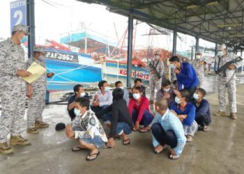 RASHIDILHADI Abd. Rashid (kiri) memeriksa nelayan Vietnam yang ditahan di jeti Kemaman, Terengganu, hari ini. - FOTO/NIK NUR IZZATUL HAZWANI NIK ADNAN