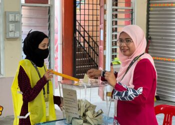 MARZUANI Ardila Ariffin (kanan) membuang undi buat kali pertama sebagai calon di SK Ketereh, Kota Bharu, Kelantan.