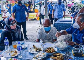 MAS ERMIEYATI Samsudin (kiri) bersama Muhyiddin Yassin (kanan) menyantuni seorang penduduk kampung di sebuah gerai di Kampung Jeram, Masjid Tanah, Melaka.