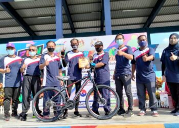 AHMAD Maslan (empat dari kanan) menyampaikan hadiah utama berupa sebuah basikal kepada pemenang cabutan bertuah dalam program kayuhan santai sempena HSN di Stadium Mini Pontian, di Johor. - UTUSAN/MUHAMMAD ZIKRI