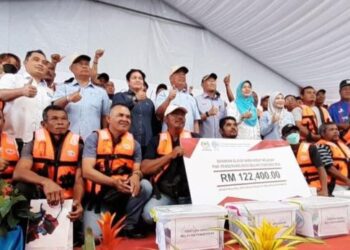 MOHAMAD Sabu (tengah) bergambar dengan penerima Bantuan Nelayan Pengerang di Kompleks LKIM Pengerang, Kota Tinggi, Johor.