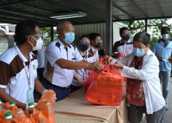 LEE Tian Hock menyerahkan sumbangan barangan makanan kepada seorang warga emas, Yap Yen Fong, 87, dalam program yang diadakan di Wisma Matrix di Seremban hari ini.-UTUSAN/ZAKKINA WATI AHMAD TARMIZI.